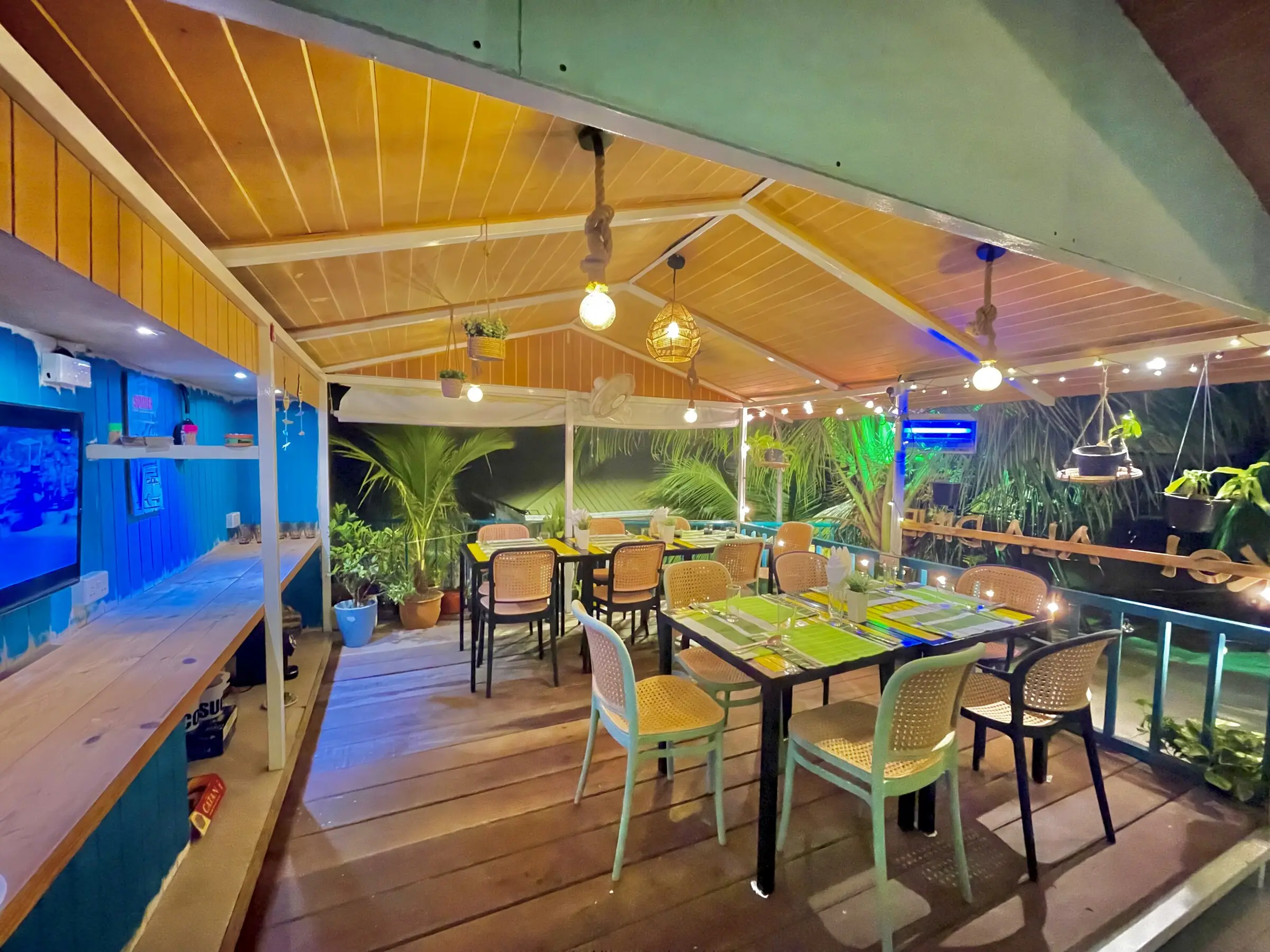 Open-air lounge and games area beside the pool at Koimala Maamigili