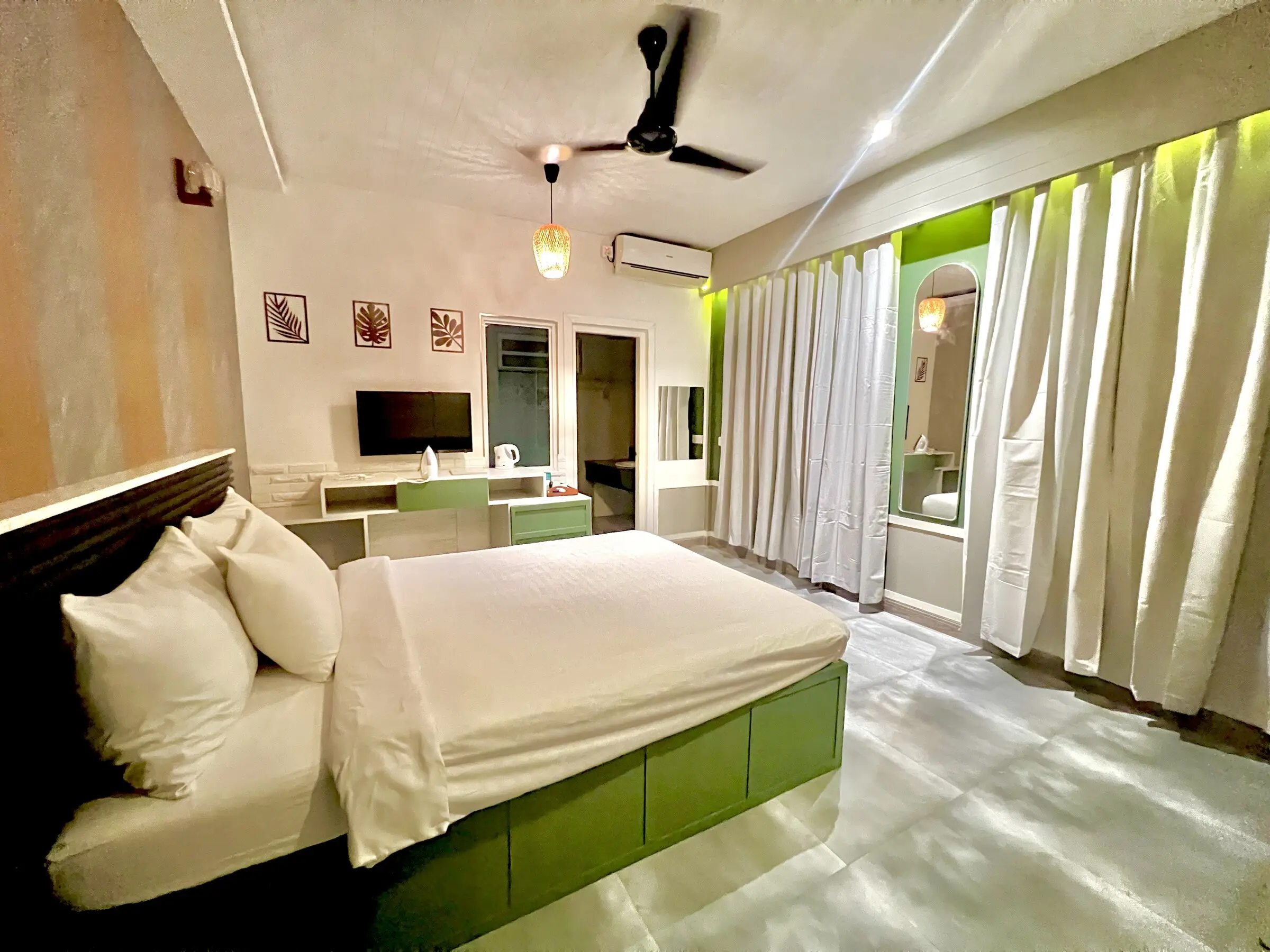 Bright room with sheer curtains and a double bed at Koimala Maamigili