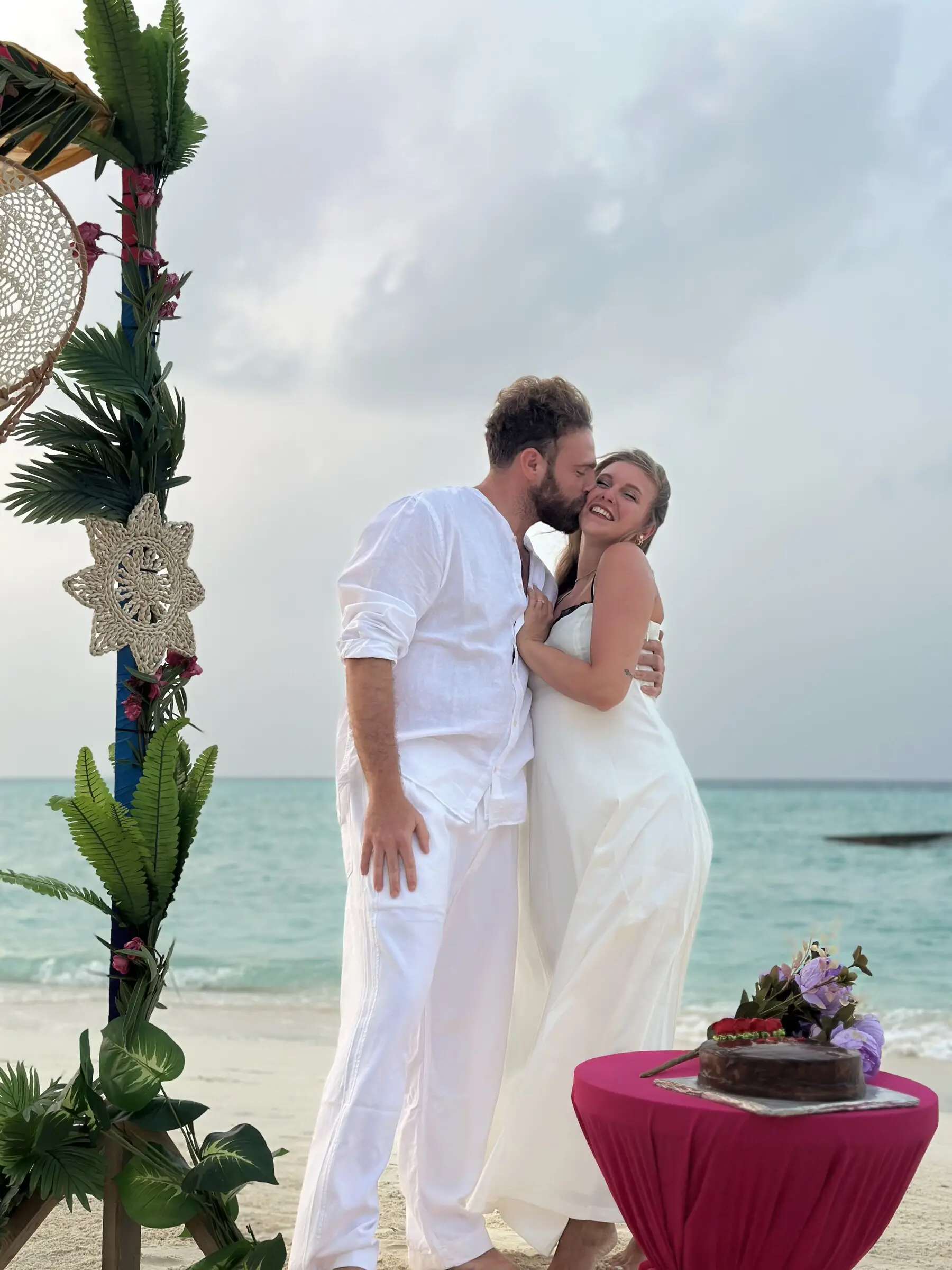Couple celebrating on Maamigili beach with floral decoration